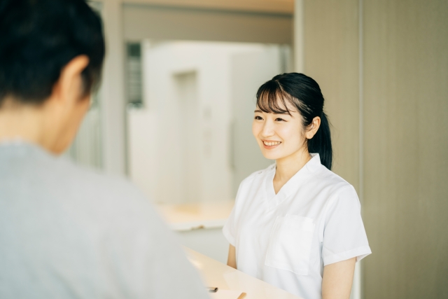 歯科医院の受付で患者様に笑顔で対応するスタッフ
